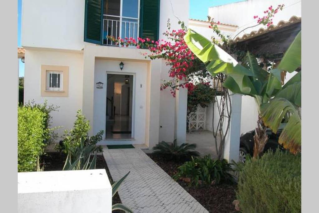 uma casa branca com uma porta e algumas flores em Villa Marisol by Sunny Deluxe em Albufeira