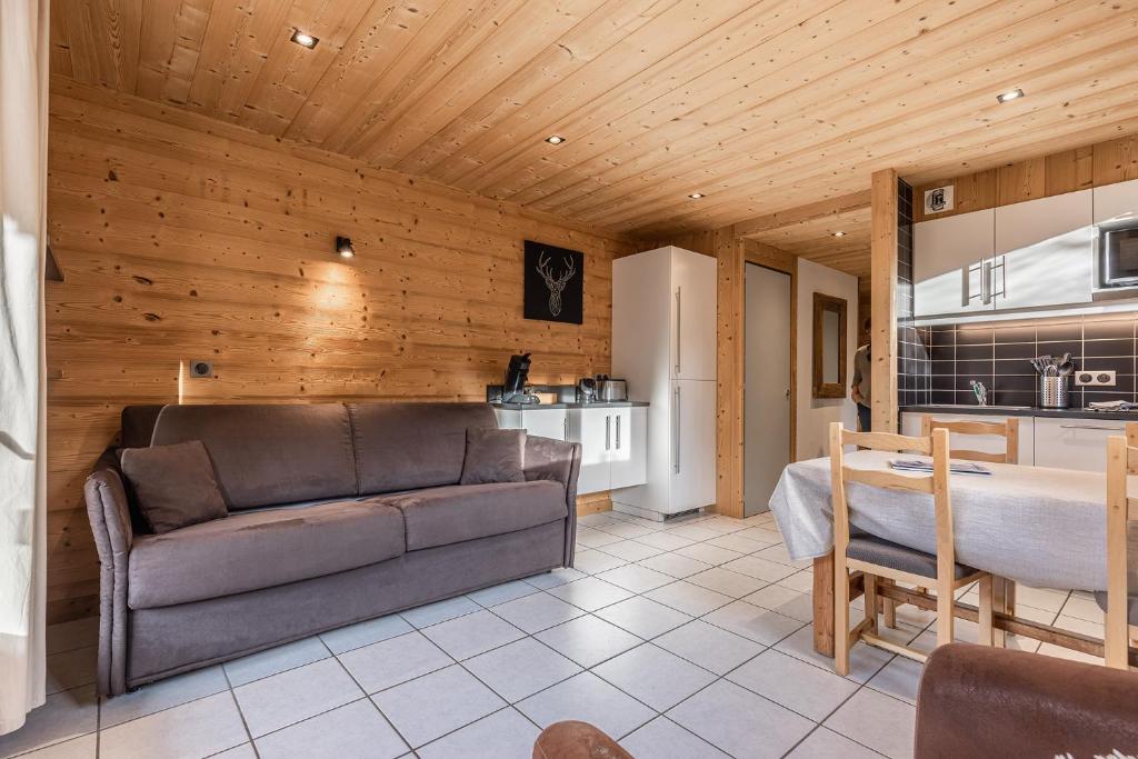 a living room with a couch and a kitchen at La Duche 101 in Le Grand-Bornand