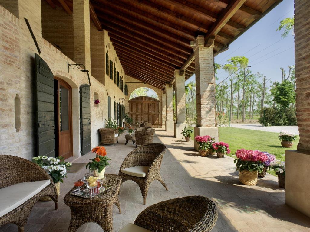 un patio esterno con sedie, tavoli e fiori di Tenuta Le Risare a Campo San Martino