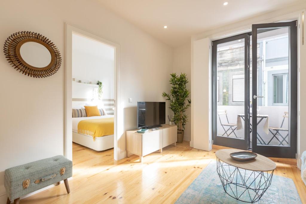 1 dormitorio con 1 cama y TV en una habitación en Sweet Flat 4Two in City Center, Balcony & Air Conditioning en Oporto