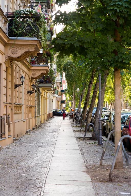 Hotel BENSIMON apartments Charlottenburg, a street with trees and buildings and a person walking down the street at BENSIMON apartments Charlottenburg in Berlin