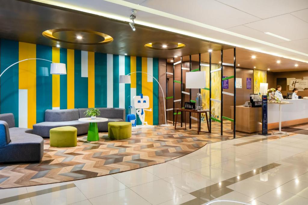 Holiday Inn Express Shenyang North Station, an IHG Hotel في شنيانغ: لوبي بحائط مخططة ملونة