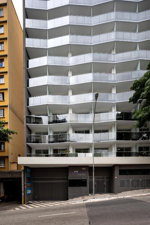 an apartment building with a parking garage in front of it at 360 Suítes Sé in São Paulo