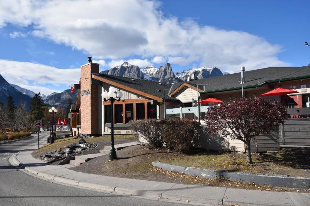 a building on a street with mountains in the background at The Drake Inn in Canmore