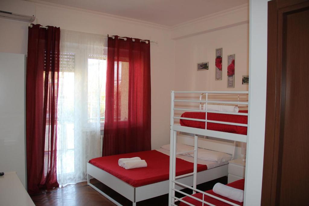 ローマにあるDomus Vatican Holiday'sの赤いカーテン付きの二段ベッド2台が備わる小さな客室です。