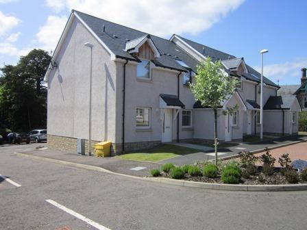 uma casa ao lado de uma rua em Bradan em Pitlochry
