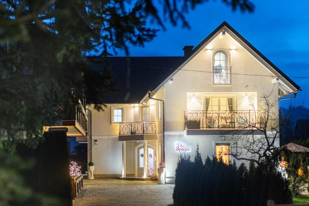 een wit huis 's nachts met lichten bij Design & Wine Vila Special Bled in Bled