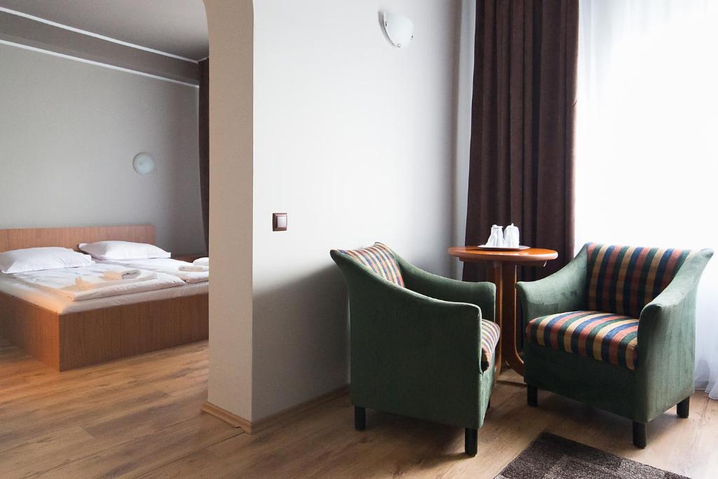 een hotelkamer met een bed en twee stoelen en een tafel bij Casa Engels in Cluj-Napoca