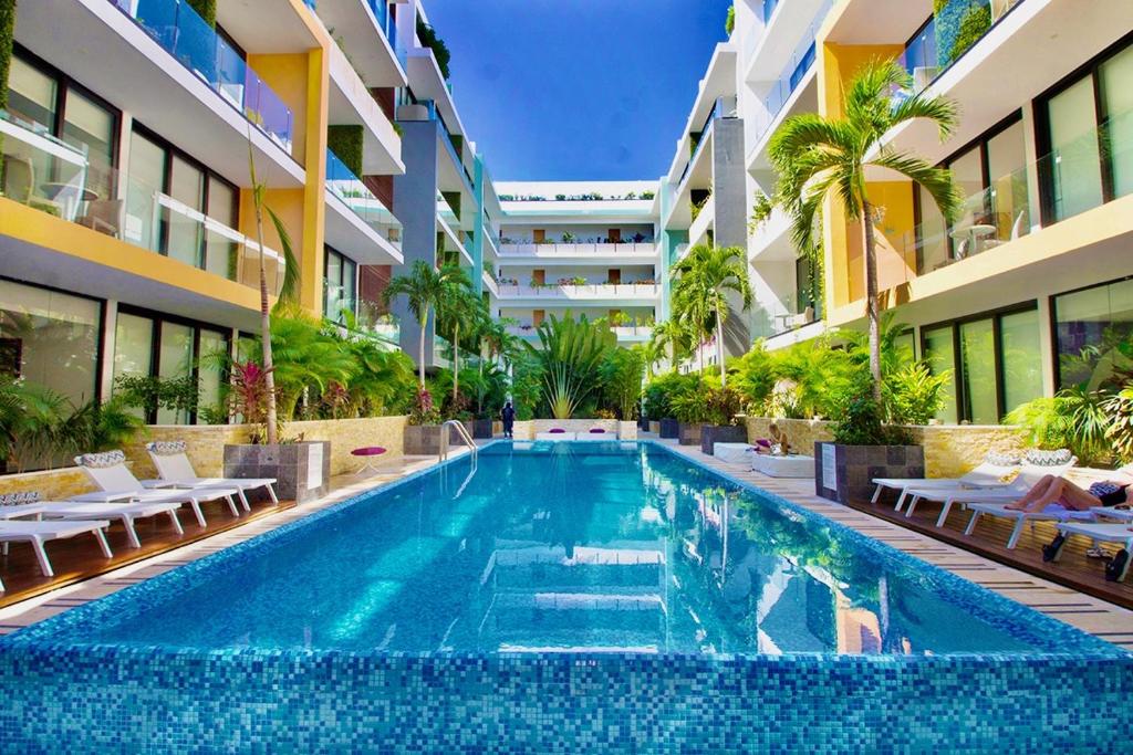 a swimming pool in the middle of a building at Menesse the City by Casago in Playa del Carmen