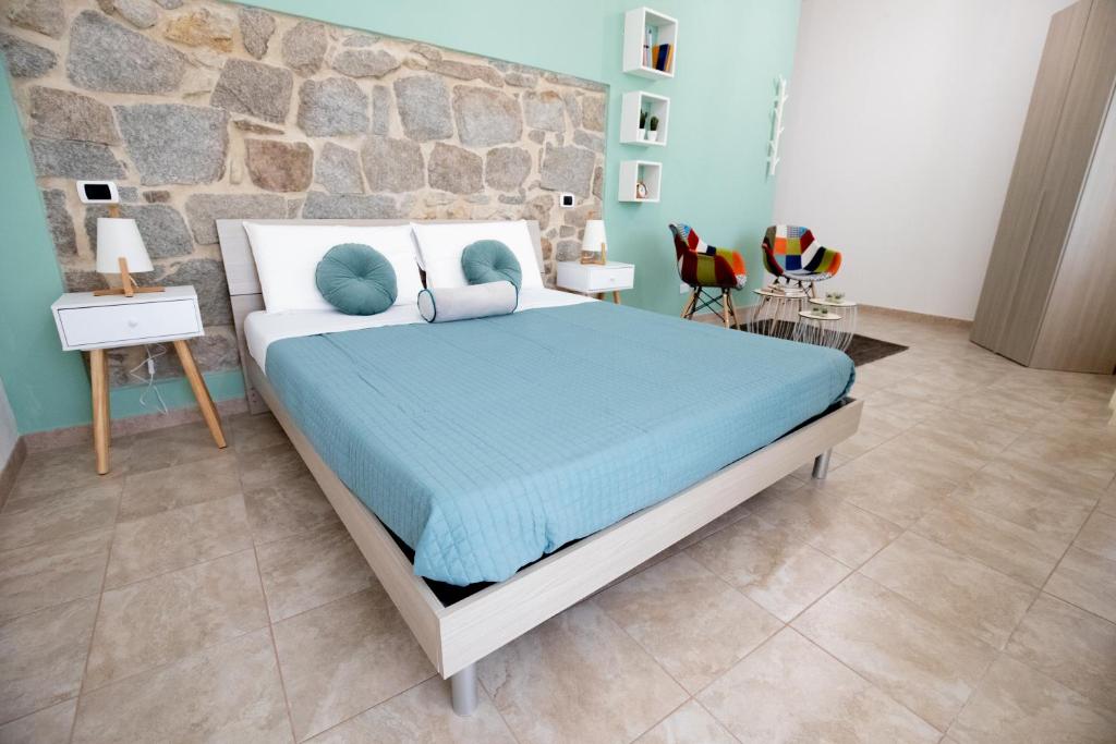 a bedroom with a bed and a stone wall at B&B Vico 10 in Guspini