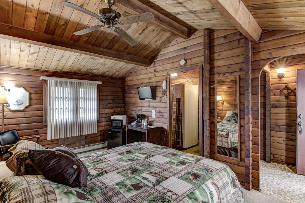 a bedroom with a bed and a ceiling fan at Rib Waters Inn in Rib Lake