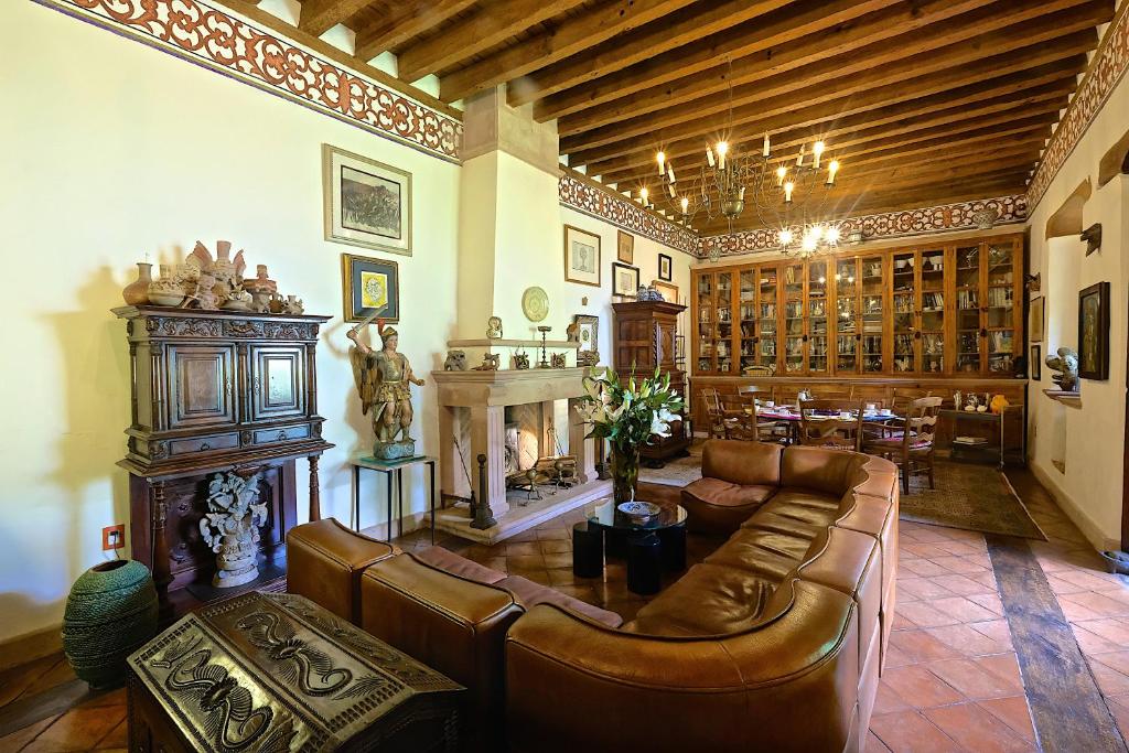 sala de estar con muebles de cuero y chimenea en Casa de la Real Aduana Boutique Hotel en Pátzcuaro