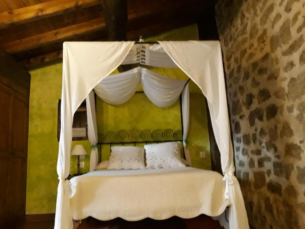 um quarto com uma cama de dossel e cortinas brancas em La Bodeguita em Cuzcurrita-Río Tirón