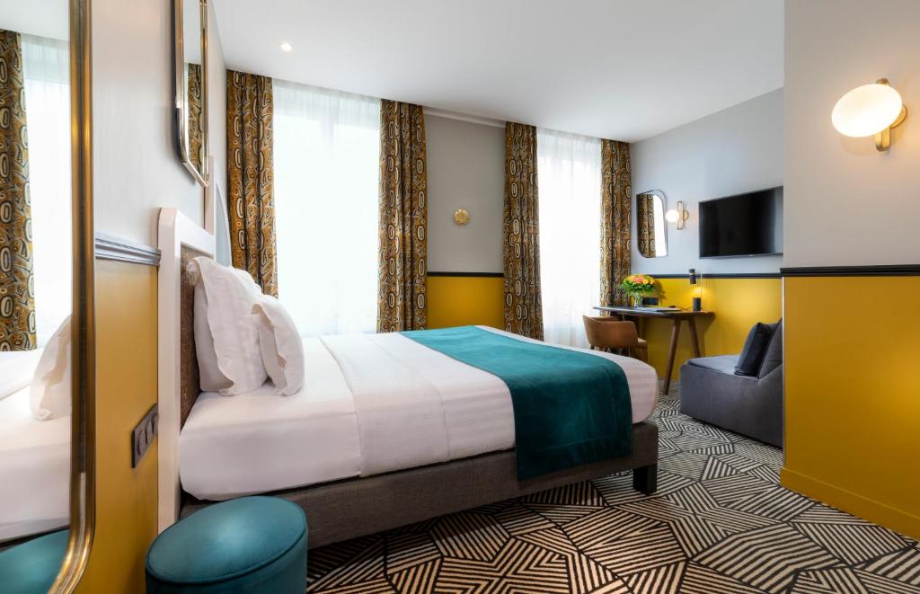 a hotel room with a bed and a couch at Hotel Elysa-Luxembourg in Paris