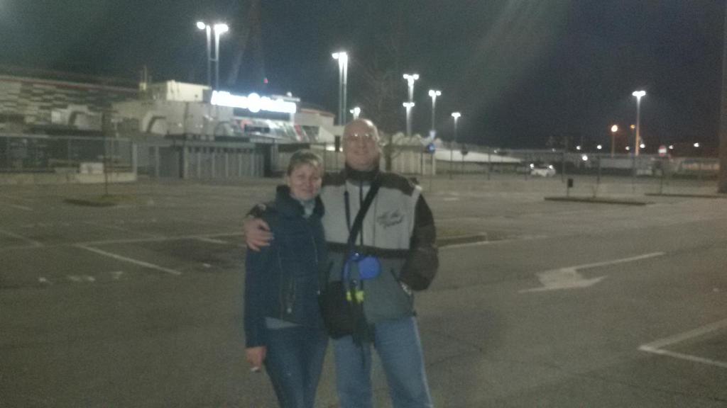 un homme et une femme debout dans un parking la nuit dans l'établissement STANZA Juventus, con servizio navetta a richiesta, à Turin