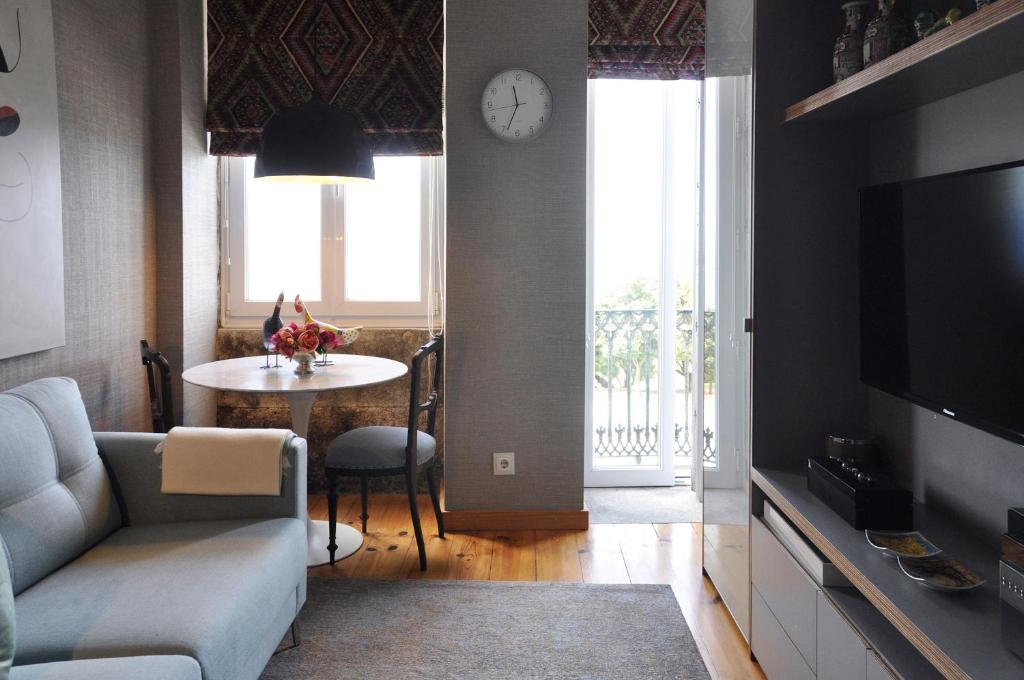 a living room with a couch and a table with a clock at Apartment by the Sea in Porto