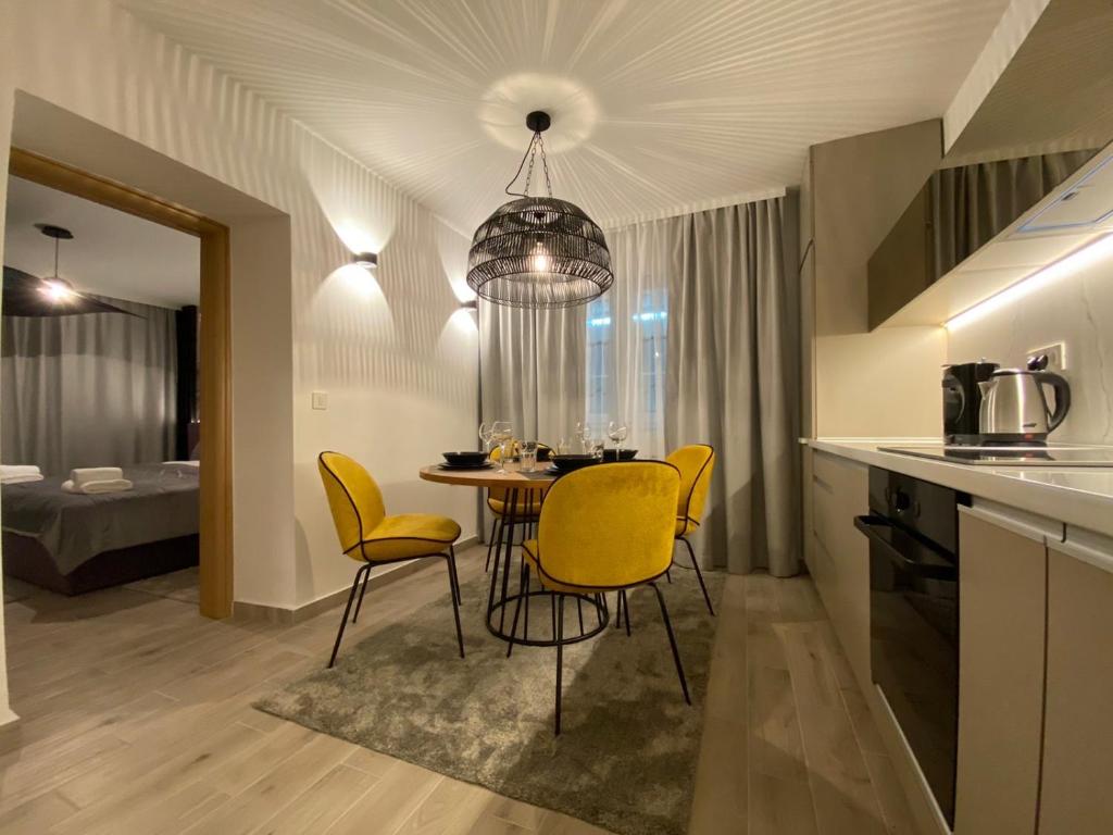 cocina y comedor con mesa y sillas amarillas en Art of Living Luxury suite two, en Sarajevo