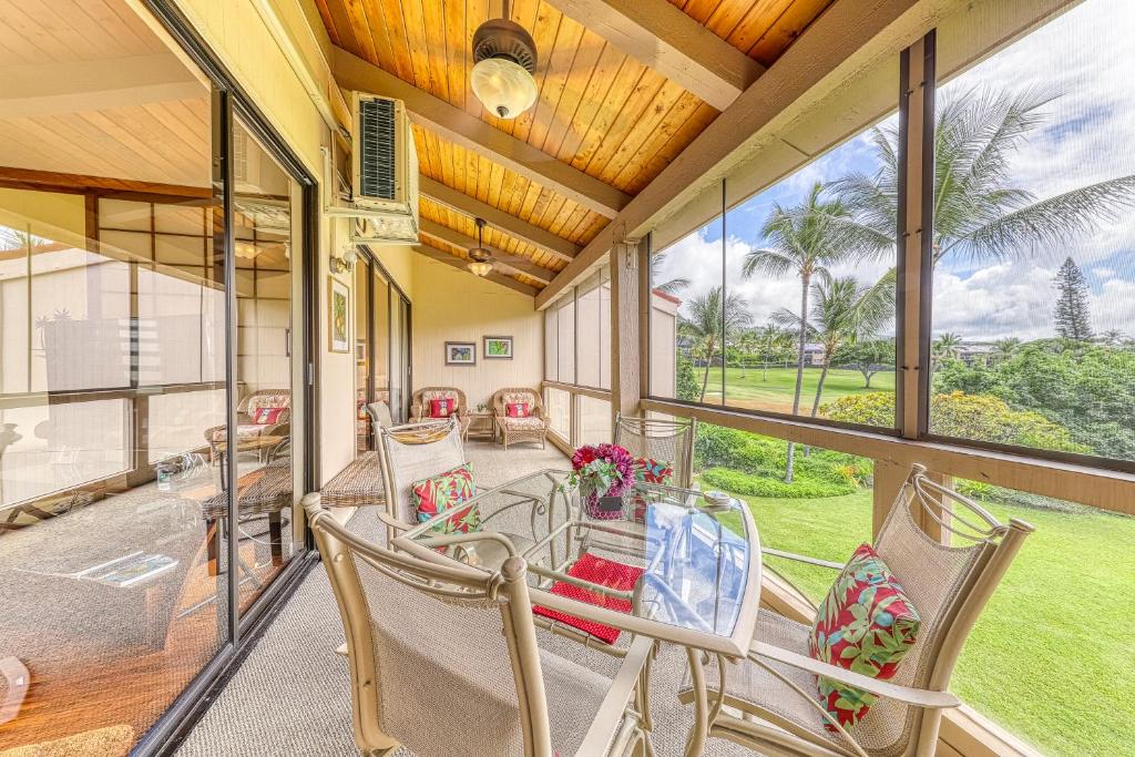 un porche cubierto con sillas y mesa en Keauhou Kona Surf & Racquet Club #7-302 en Kailua-Kona