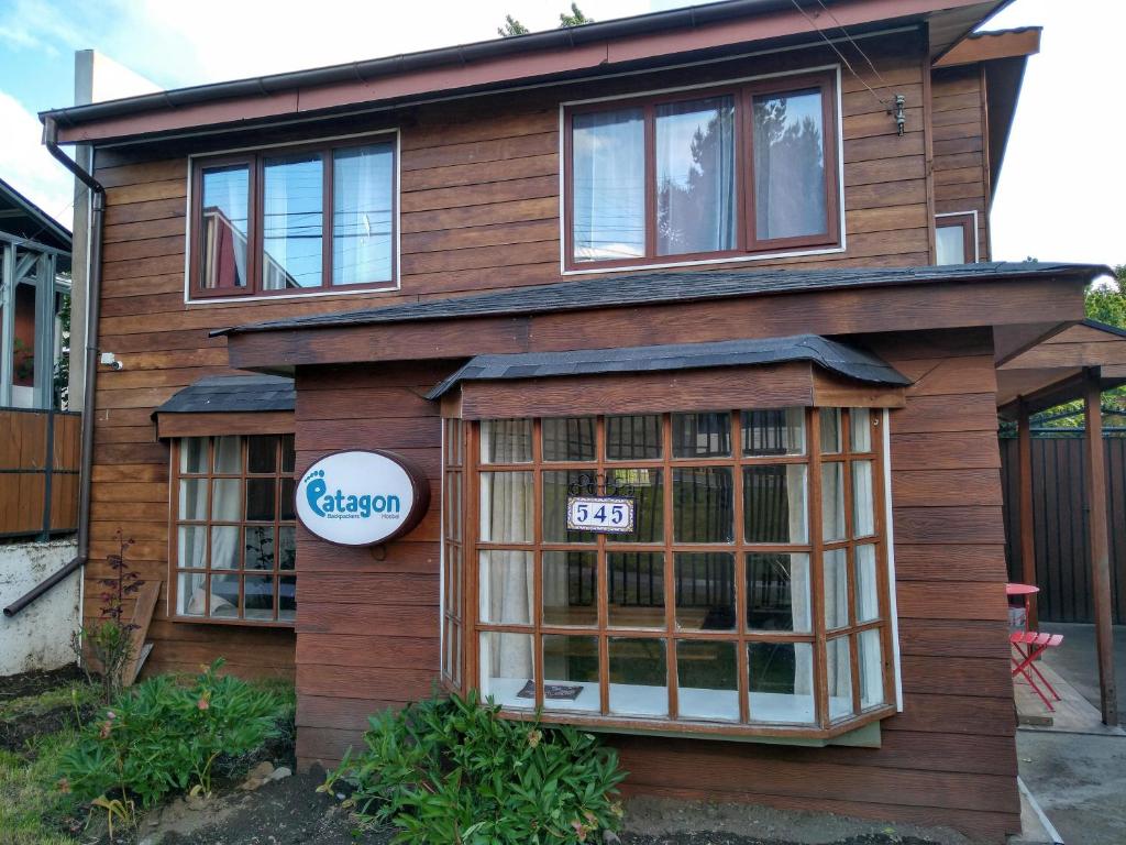 a house with a sign on the front of it at Patagon Backpackers in Coihaique