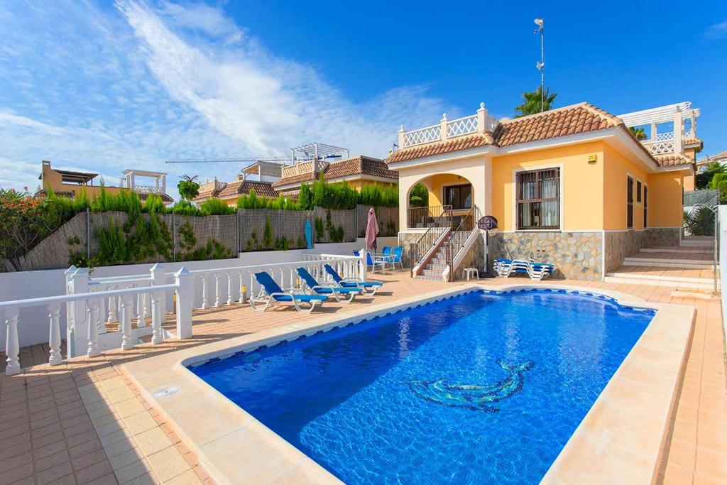 a villa with a swimming pool in front of a house at CH Villa Isla Espalmador Ciudad Quesada in Ciudad Quesada