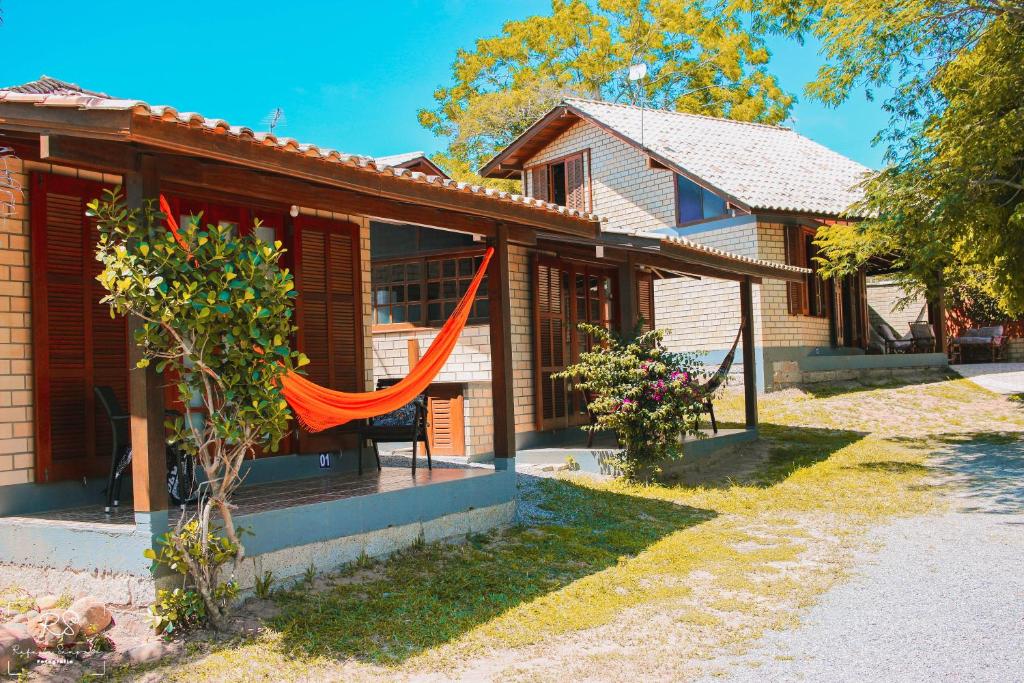 a house with a hammock on the porch at Morada Quatro Elementos in Praia do Rosa