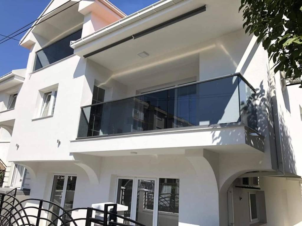 ein weißes Haus mit einem großen Glasbalkon in der Unterkunft Gold Apartment in Strumica