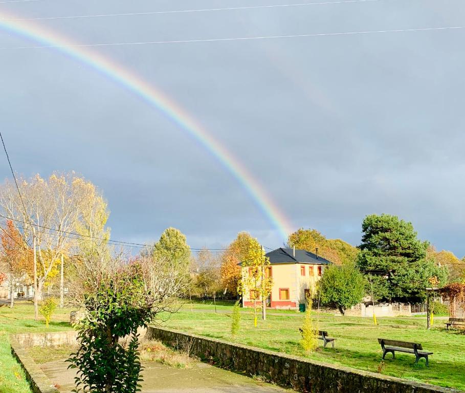 a rainbow in the sky over a park with a bench at Casa Dono Sanabria in Cobreros
