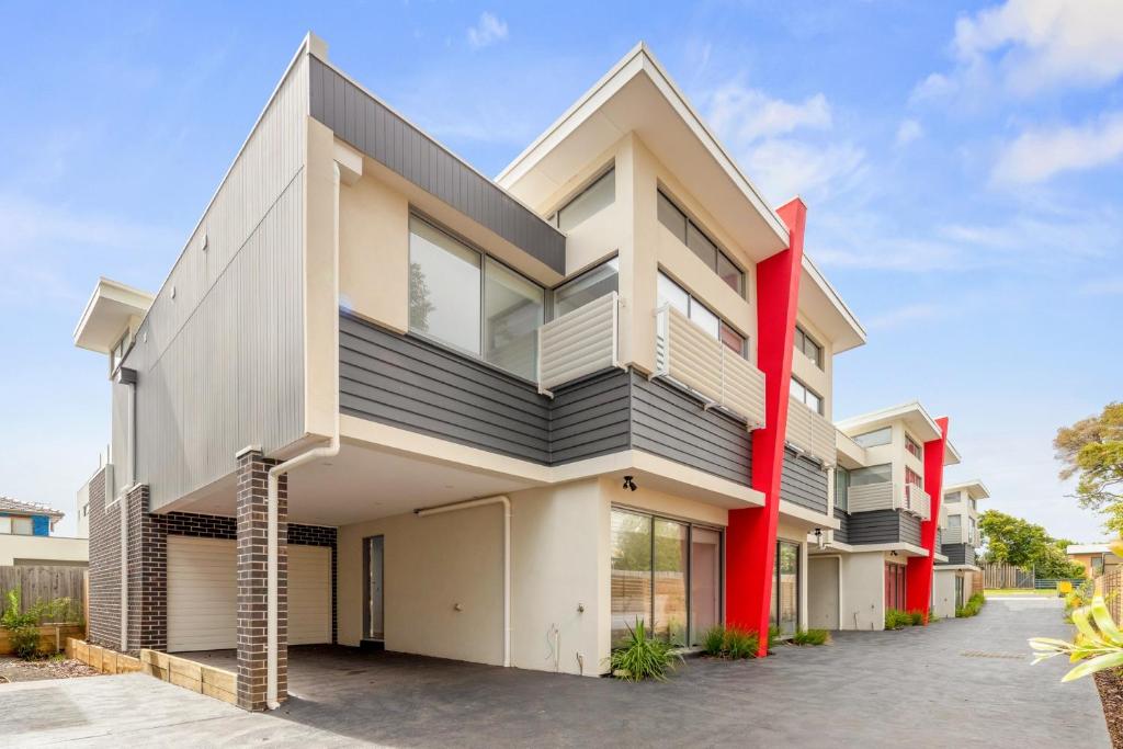 a house with a red and white facade at Phillip Island Townhouses in Cowes