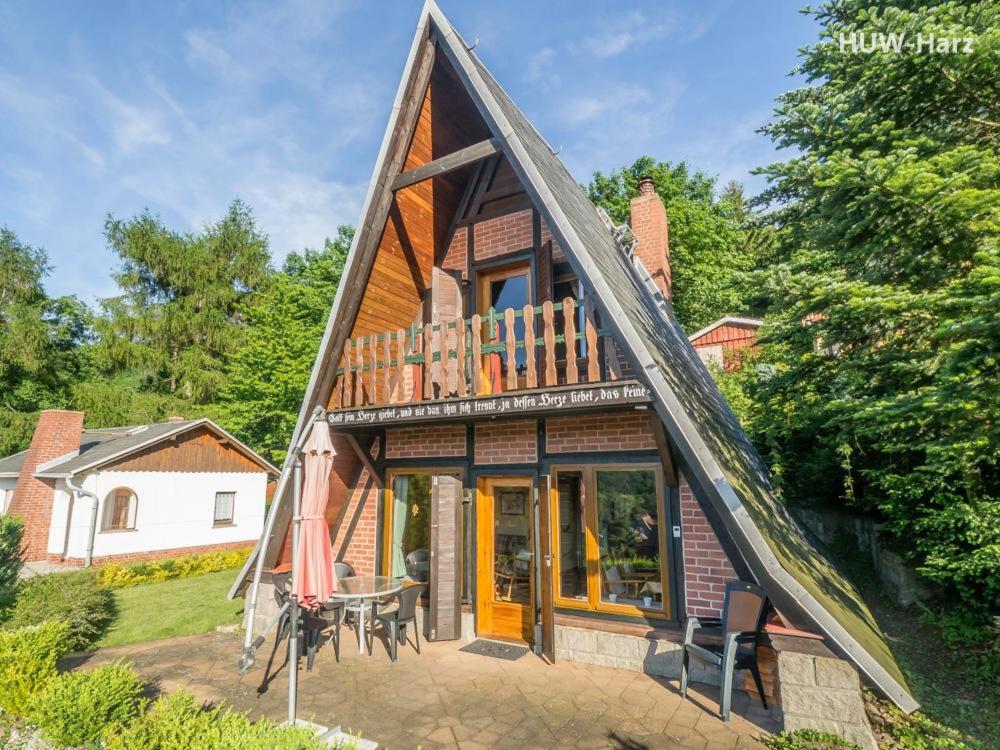 een huis met een gambrel dak en een patio bij Finnhütte am Kapitelsberg in Wernigerode