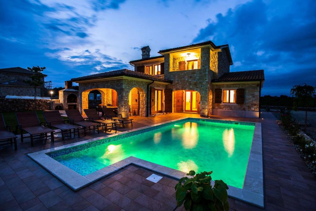 a large swimming pool in front of a house at Villa Polonijo in Vrh