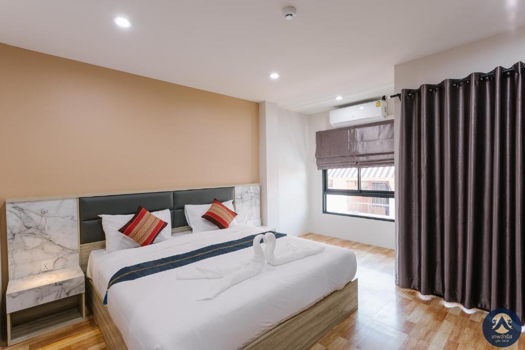 Postel nebo postele na pokoji v ubytování Thepchamrat Boutique Hotel