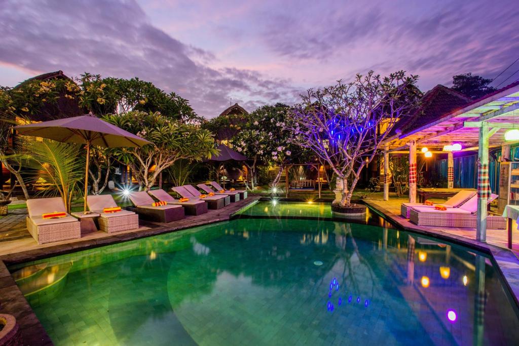 a swimming pool with lounge chairs and a resort at Nanuk's Bungalows in Nusa Lembongan