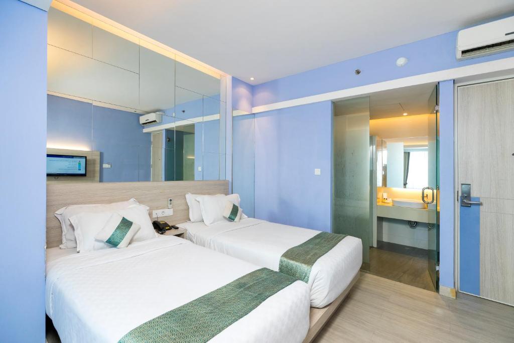 Postel nebo postele na pokoji v ubytování Royal City Hotel Jakarta