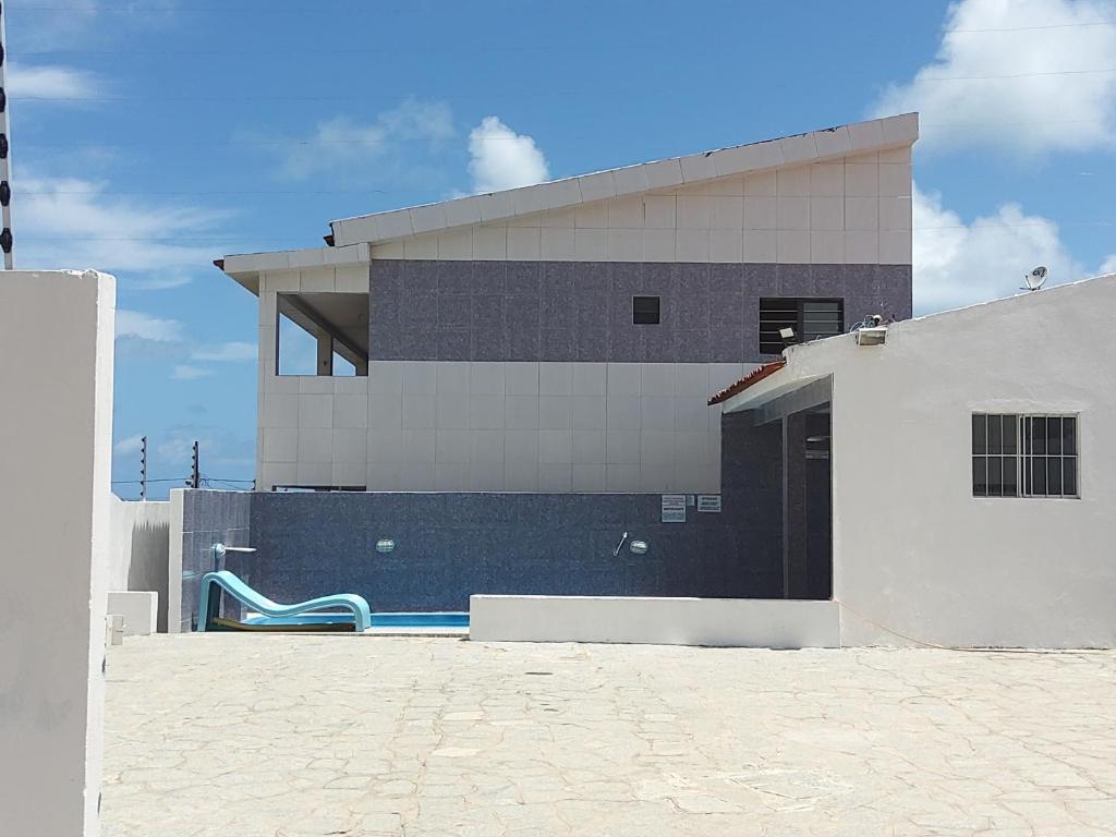 a building with a swimming pool in front of it at Residencial Água Viva Extra in Jacumã