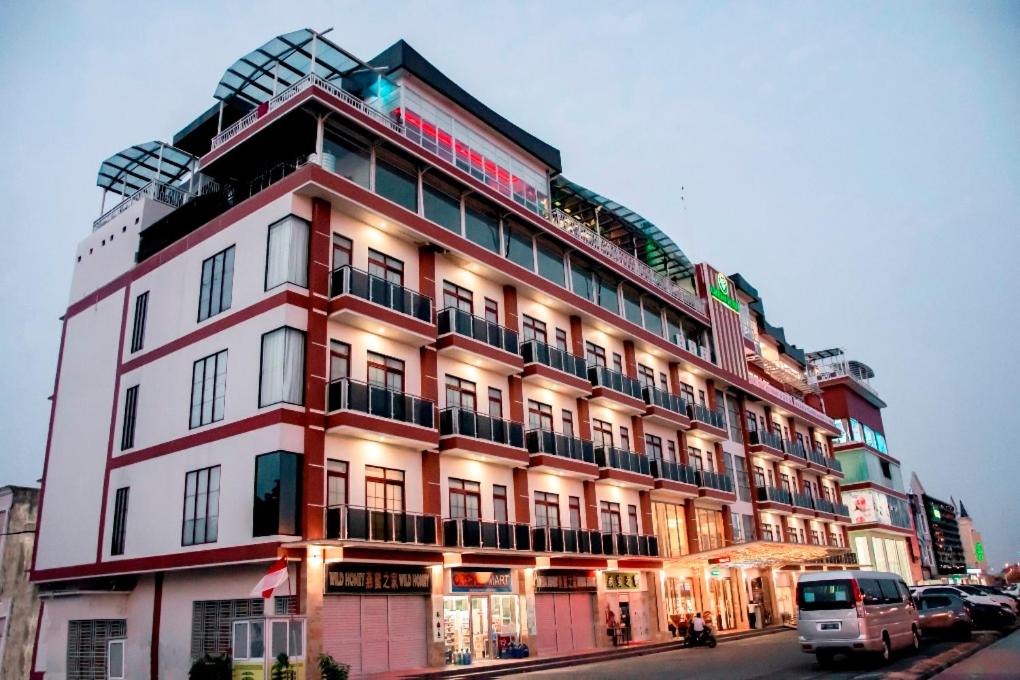 a large red and white building on a city street at Green Rose Hotel in Batam Center