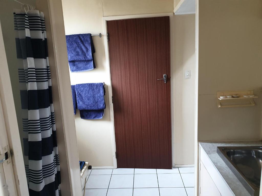 bagno con porta marrone e asciugamani blu di castletown motel a Foxton