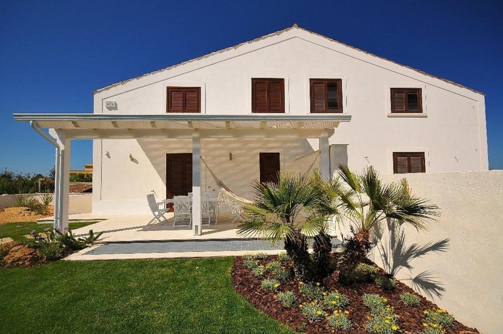 a white house with a porch and palm trees at Villa Elen in Marsala