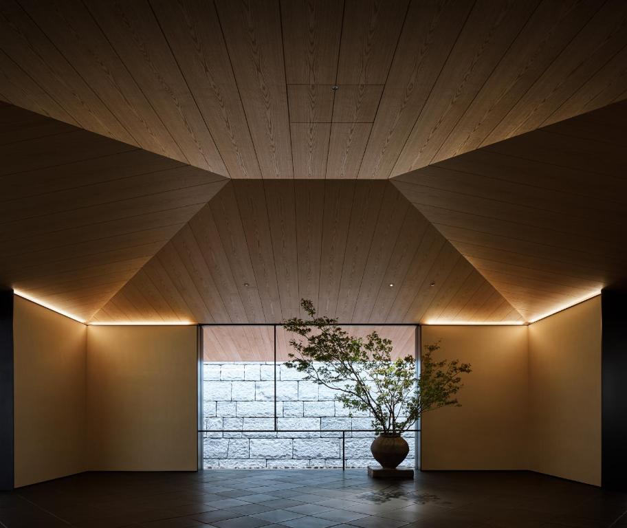 a plant in a vase in a room with a ceiling at Park Hyatt Kyoto in Kyoto