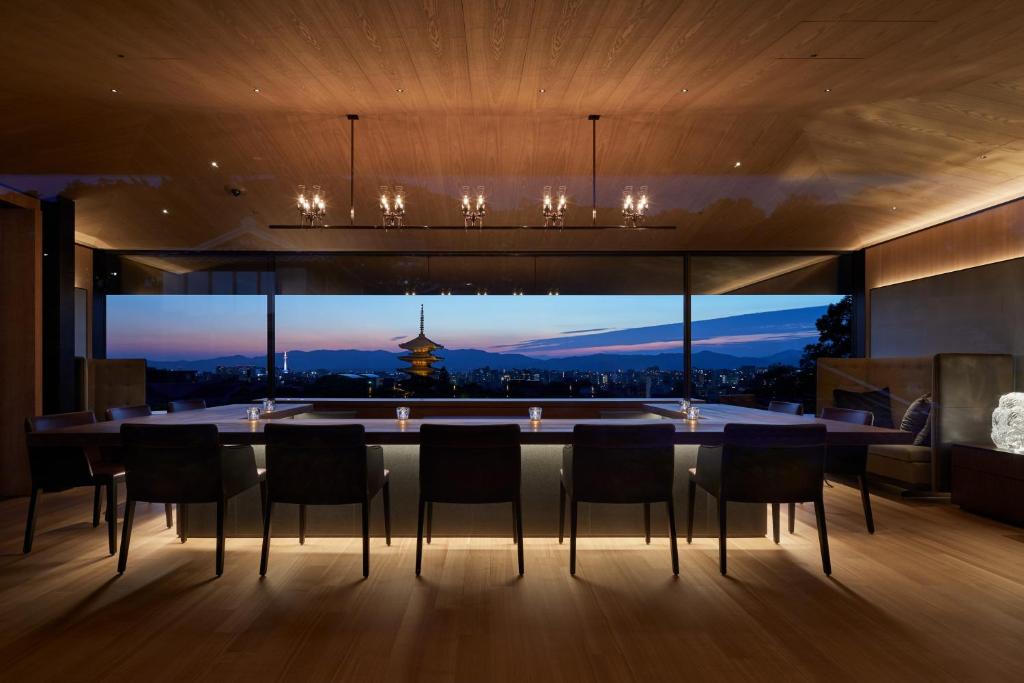 a dining room with a table and a large window at Park Hyatt Kyoto in Kyoto