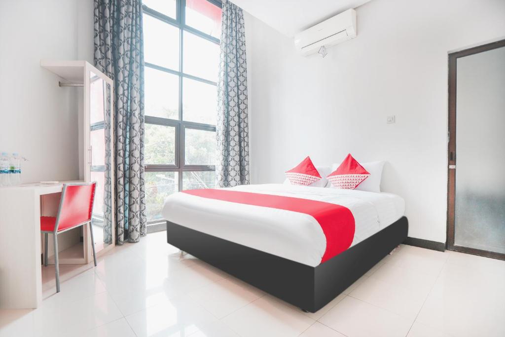 - une chambre avec un lit, une table et une fenêtre dans l'établissement OYO 148 Cempaka Place Homestay, à Jakarta