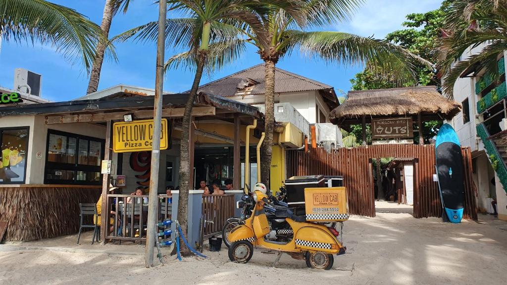 
a yellow truck parked next to a palm tree at Boracay Pito Huts in Boracay
