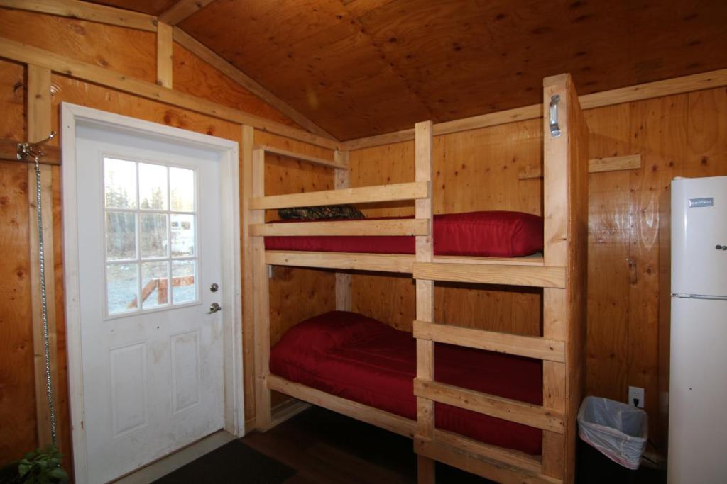 a bedroom with bunk beds in a log cabin at Alaskan Adventure Dry Cabins in Pleasant Valley