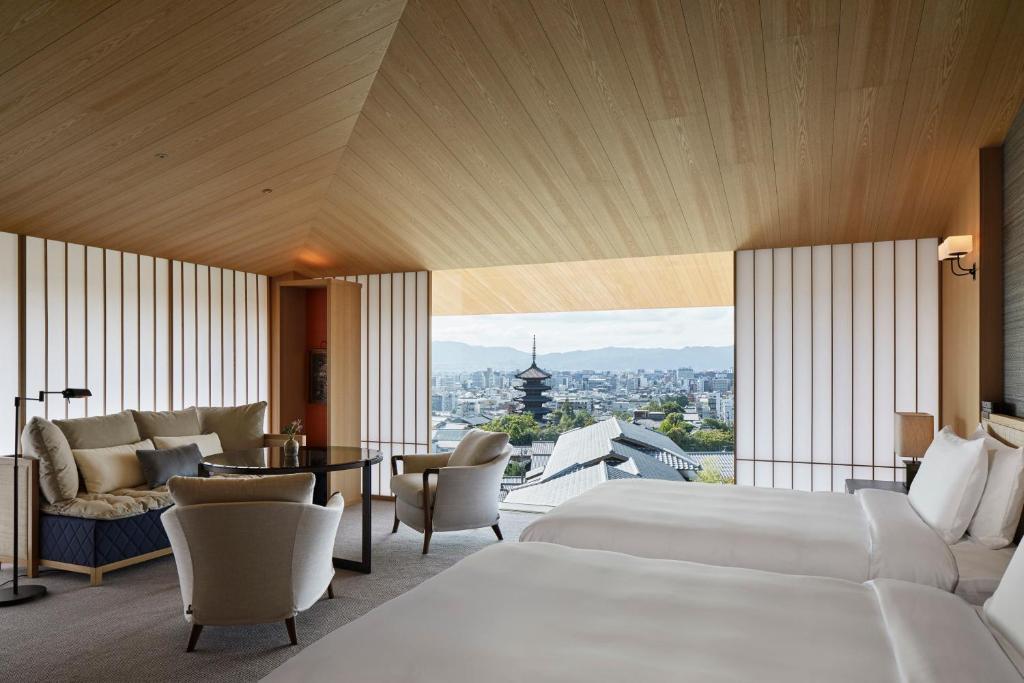 a hotel room with two beds and a large window at Park Hyatt Kyoto in Kyoto