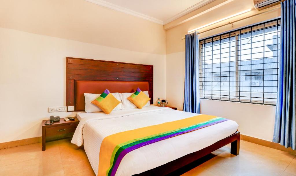 um quarto com uma cama grande e um cobertor colorido em Itsy By Treebo - Ammu Regency em Thrissur