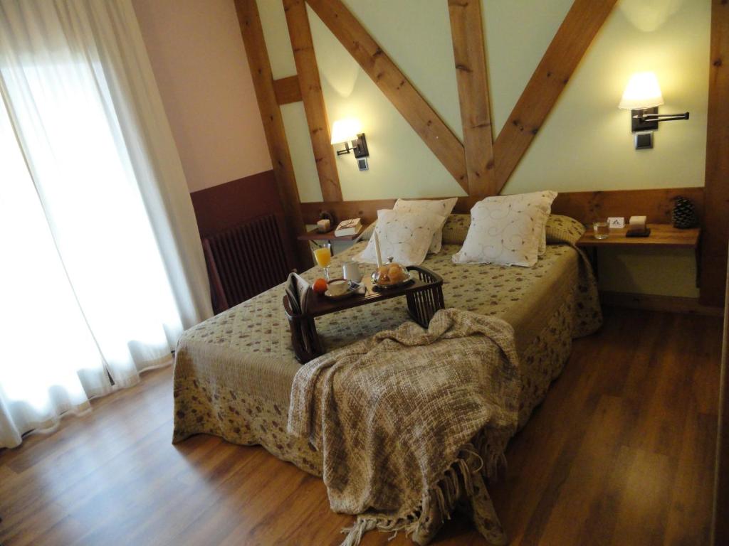 a bedroom with a bed with a table on it at Hotel Rural El Valle in Rascafría