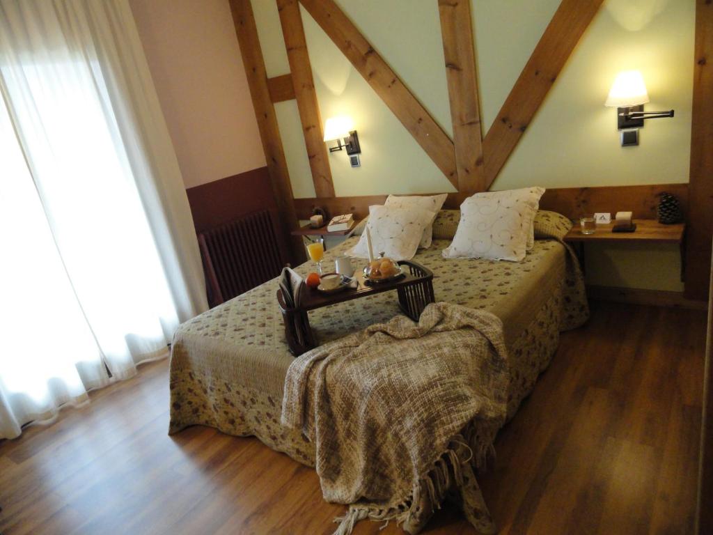Un dormitorio con una cama con una mesa encima. en Hotel Rural El Valle, en Rascafría