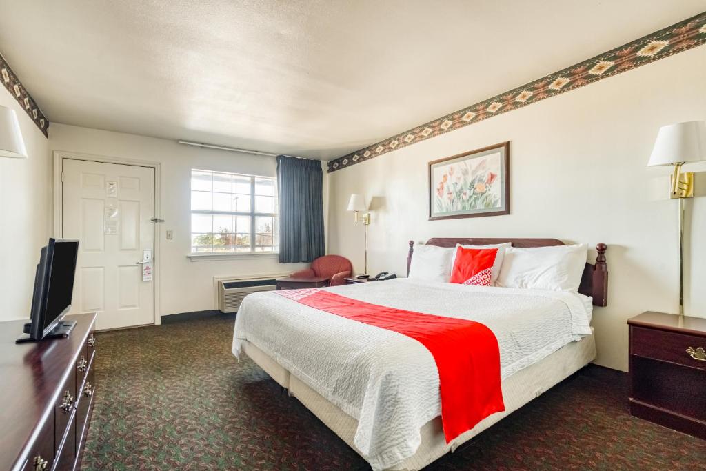 a hotel room with a large bed and a television at OYO Hotel Wichita Falls I-44 Sheppard Airforce in Wichita Falls