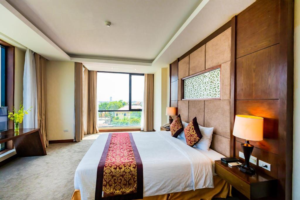 1 dormitorio con cama grande y ventana grande en Muong Thanh Holiday Quang Binh Hotel, en Dong Hoi