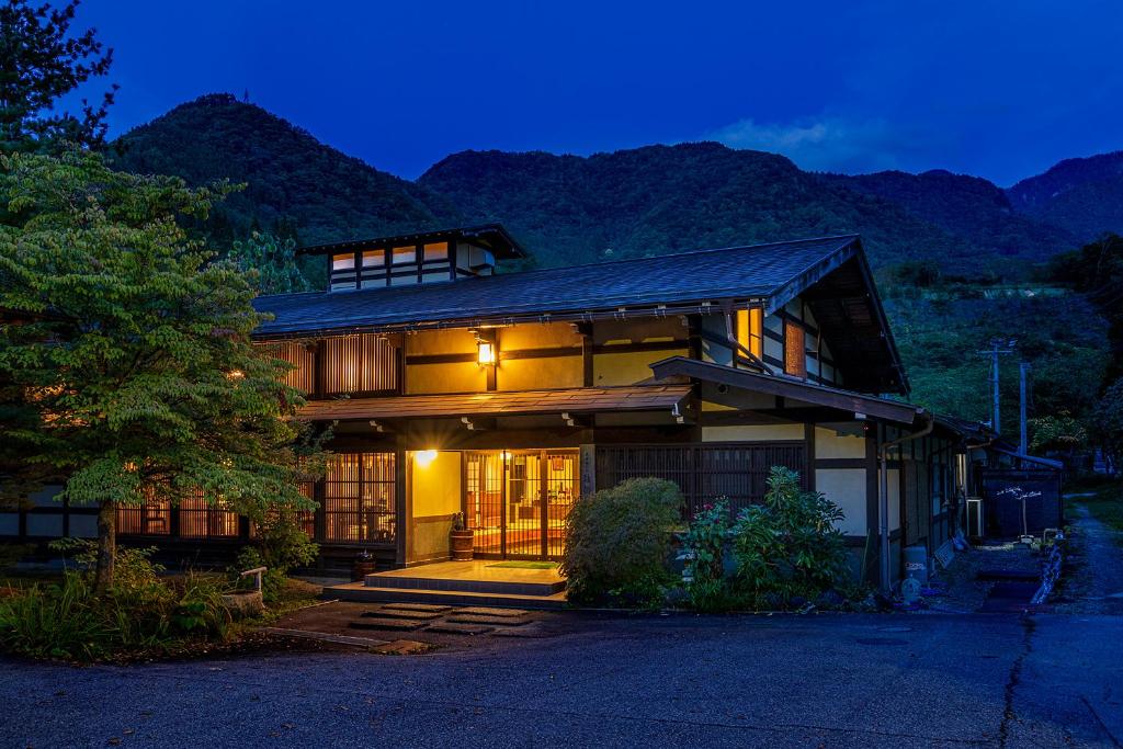 una casa grande con montañas en el fondo en Furusato, en Takayama