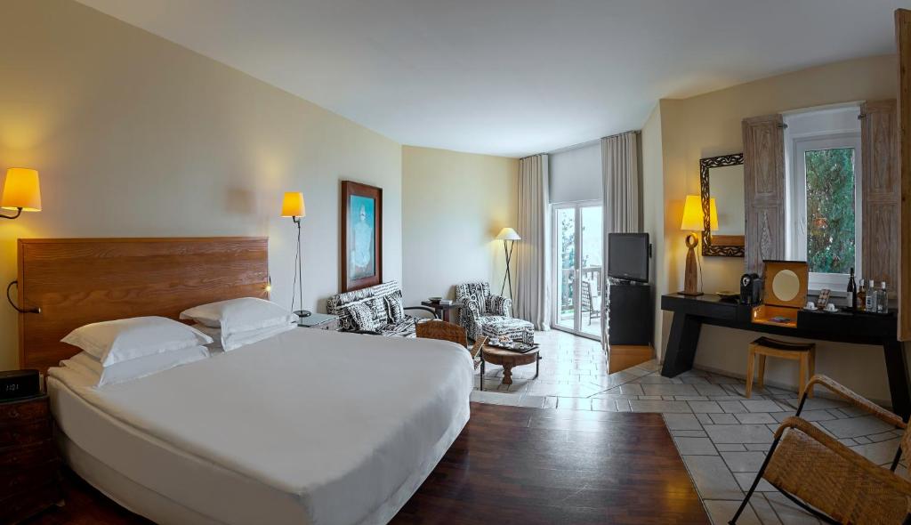 a bedroom with a large bed and a living room at The Marmara Bodrum - Adult Only in Bodrum City